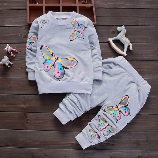 Front view of a charming Girls’ Grey Jogging Suit featuring a vibrant butterfly design. Made from a soft, breathable cotton blend, this stylish and comfortable outfit is perfect for playdates and casual outings. The elastic waistband and cuffs ensure a snug fit, available in various sizes and colors. Ideal for active girls who love fun, fashionable attire.