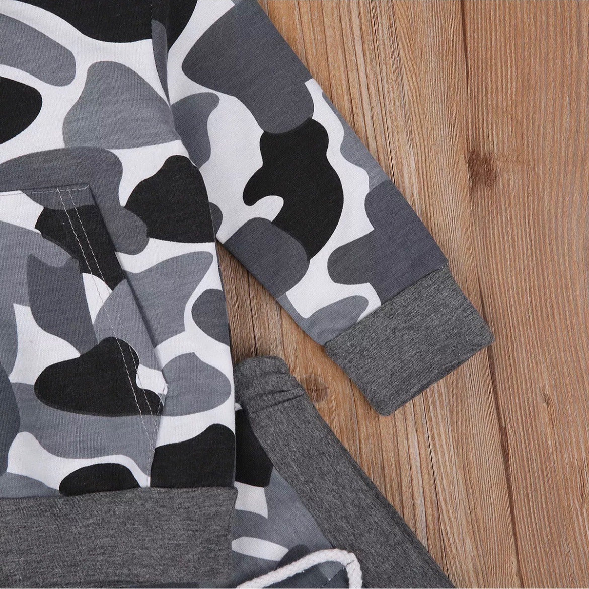 Boys camo hoodie and jogger suit with stylish black,grey, and white camouflage print, featuring a front kangaroo pocket. perfect for active kids who love adventure and outdoor play, this trendy outfit offers durability and flexibility for everyday wear.