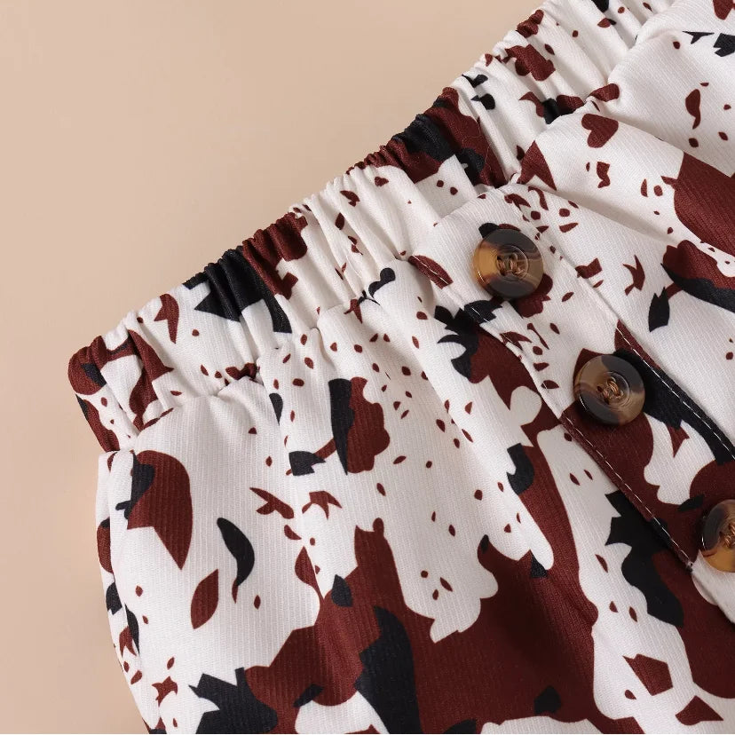 Detail of the cow print skirt from the Girls’ 3-piece Shoulder Flair Shirt and Hair Bow Set, featuring a playful and trendy pattern perfect for young fashionistas.”